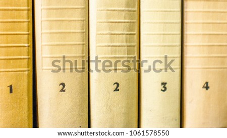 Collection of numbered books in a yellow cover on a shelf