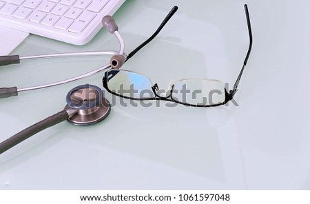 doctor desk with glasses,keyboard,mouse pad and stethoscope with copy test space