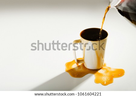 Coffee spilling out of a cup Royalty-Free Stock Photo #1061604221
