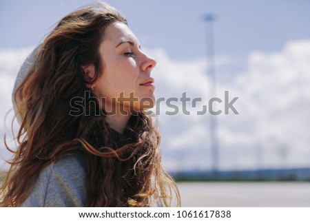 Young woman resting after run wearing a sweatshirt and breathing deeply Royalty-Free Stock Photo #1061617838
