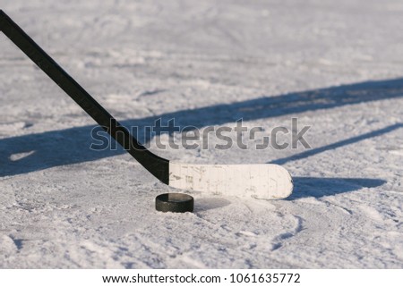 close-up stick and puck on the ice background