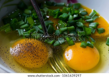 Egg yolks with freshly cut spring onion. Ingredients for delicious scrumbled eggs. 