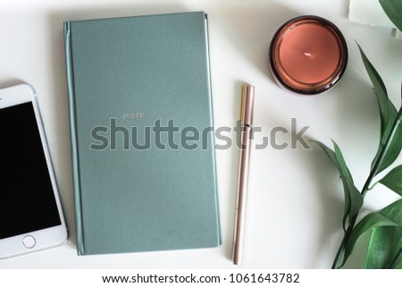 Business desktop with notebook copy space, candle and pink pen. Top view