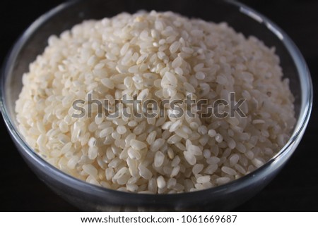 White rice texture and background in glass bowl. Grey background.