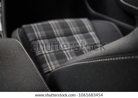 Front grey seat with white stitching. Seat of a luxury sports car. Checked pattern. 