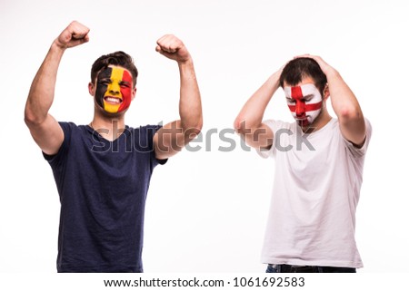 Happy Football fan of Belgium celebrate win over upset football fan of England with painted face isolated on white Royalty-Free Stock Photo #1061692583