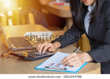 Close-up photos of young business woman or young woman owner making calculations. Savings, finances and economy concept.