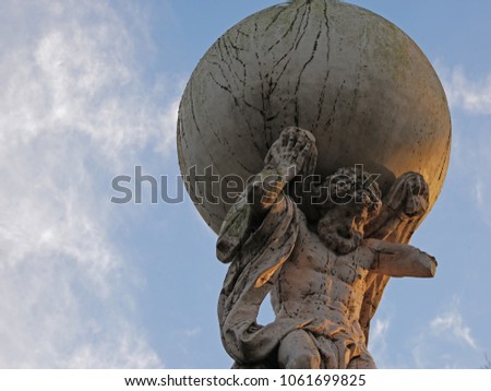 Upwards view to statue of Atlas with blue sky with few clouds in the park Royalty-Free Stock Photo #1061699825