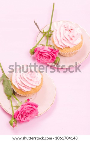 Cupcake with pink cream decoration and roses on pink pastel background - romantic vertical banner for congratulation card for birthday or wedding.