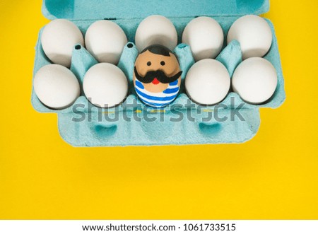 The concept of Easter with cute and cheerful handmade eggs,a strongman.Circus Yellow background. Funny egg. Painted Easter eggs in different moods and facial expression 
