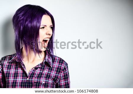 Portrait of a aggressive punk girl with purple hair.