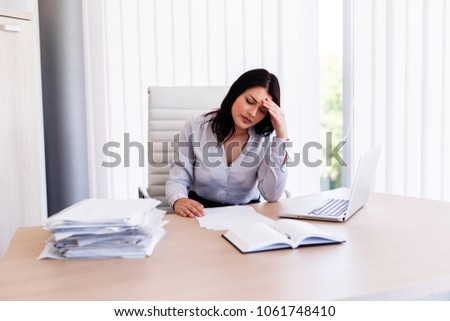 Businesswoman having headache in her office after doing very hard work