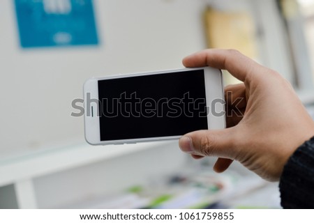 Close up on hand using mobile phone with blank copyspace display for advertising text message or content mockup background. Professional payment technology, game playing, video filming or photography