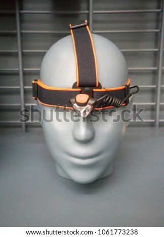 Black and orange flashlight on grey head model for store display