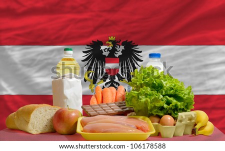 complete national flag of austria covers whole frame, waved, crunched and very natural looking. In front plan are fundamental food ingredients for consumers, symbolizing consumerism