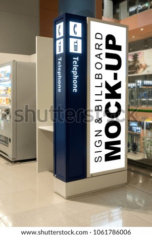 Mock up blank vertical advertising signboard on the wall of public telephone booth inside terminal with clipping path, nearly beverage vending coin machine