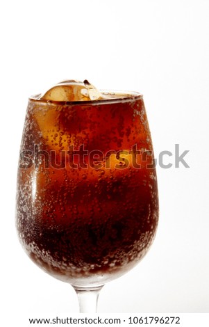 Glass of water / Cola is a sweetened, carbonated soft drink, made from ingredients that contain caffeine