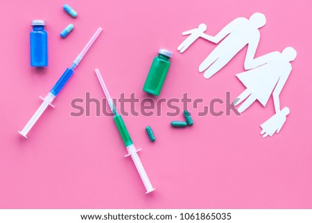 Vaccination as way to save healthy family. Syringe with colored vaccine near silhouette of family on pink background top view