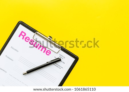 Looking for work concept. Resume on padwith on yellow background top view space for text