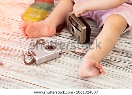 Little girl is playing with two cameras