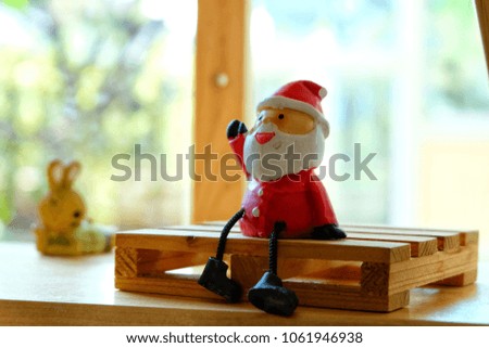 Santa Claus sitting on a wooden chair in a cafe.