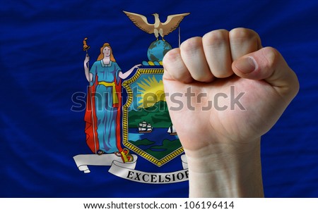 complete american state of new york covers whole frame, waved, crunched and very natural looking. In front plan is clenched fist symbolizing determination