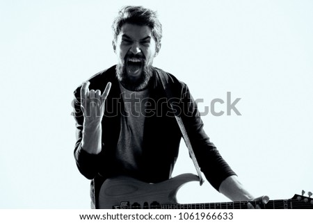  musician screams showing signs with his fingers, guitar, musical instrument                              