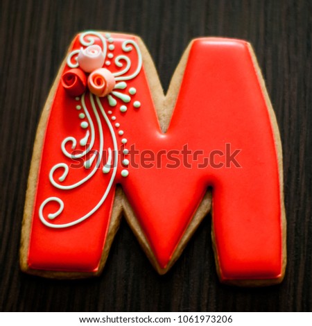 Homemade cookies, honey gingerbread with red sugar icing. Letter for the word mom with flowers