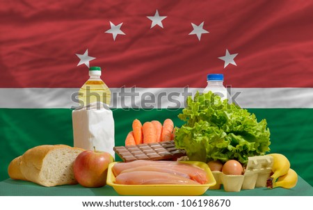 complete national flag of maghreb covers whole frame, waved, crunched and very natural looking. In front plan are fundamental food ingredients for consumers, symbolizing consumerism