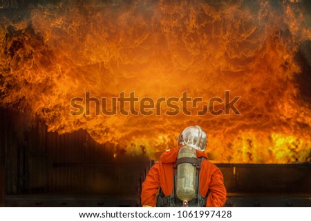 Firefighter with fire and suit for protect fire fighter for training firefighters. Selected focus.