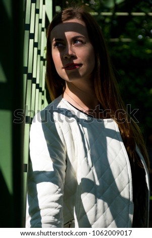 shadow of the lattice falls on the girl's face, a portrait of a young woman