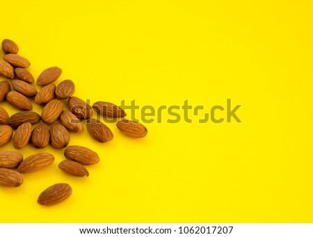 Raw Natural Organic Almonds Nuts Scattered Isolated on Yellow Background Top View Healthy Fod for Life Natural Light Selective Focus