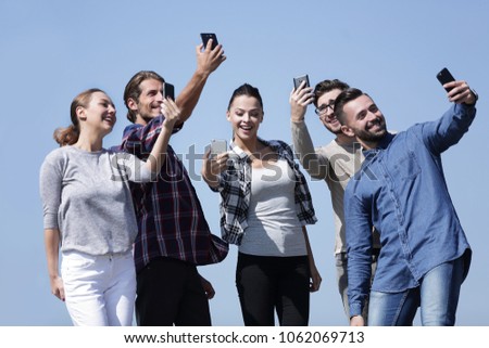 group of students taking selfie with smartphone
