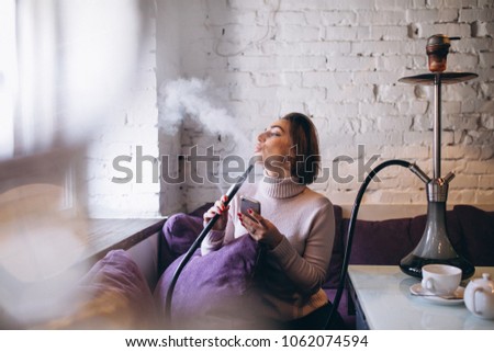 Woman with phone smoking shisha
