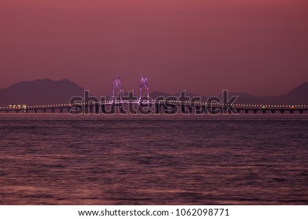 Hong Kong-Zhuhai-Macau bridge is the longest sea link in the world with undersea tunnel. Hong Kong part of bridge. Dramatic sunset sky on background. Royalty-Free Stock Photo #1062098771