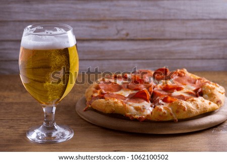 Beer and pizza. Glass of beer. Ale and appetizer snack.