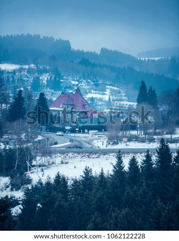 Villa near roads in misty snowy mountain valley. Winterberg, Germany.