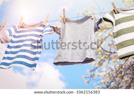 Rope with clean clothes outdoors on laundry day Royalty-Free Stock Photo #1062156383