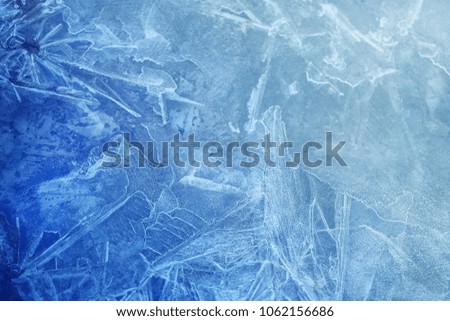 Photo background bright blue frosted thin ice with cracks in the spring