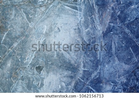 Photo background bright blue frosted thin ice with cracks in the spring