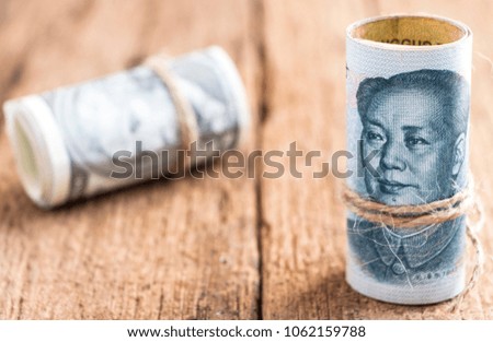 US dollar versus china yuan banknote on the wooden table background. The concept of business growth, financial or trade war.
