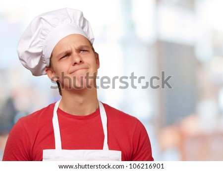 young cook man having an idea against an abstract background