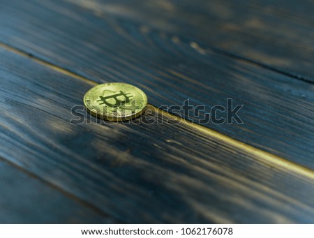 Bitcoin on a dark scorched wooden background.