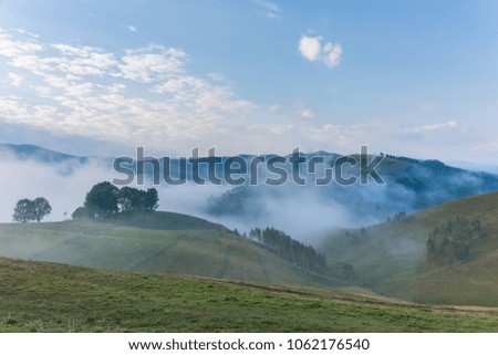 Beautiful mountain landscape of a foggy morning with and old house, trees and clouds, Dumesti, Salciua, Apuseni, Romania