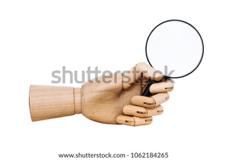 Hand with magnifying glass looking at  books. magnifier lens. wooden human  hand isolated on white background. 