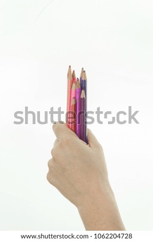 hand with colored pencils on white background