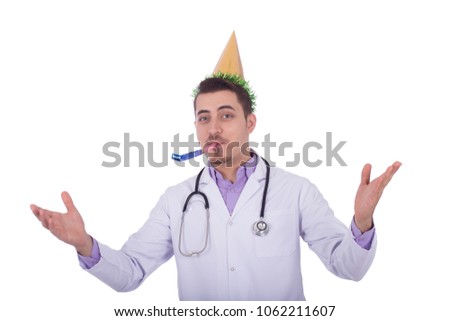 Funny doctor wearing his uniform and a party cone and blowing in horn with arms wild open, isolated on white background