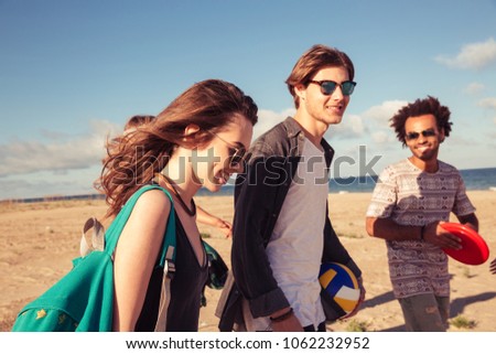 Picture of amazing young group of friends walking outdoors on the beach.