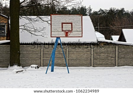 Basketball shield on an empty sports ground under the snow