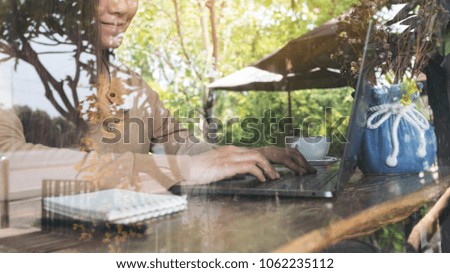 Closeup image of business woman working and typing on laptop keyboard on wooden table in cafe 